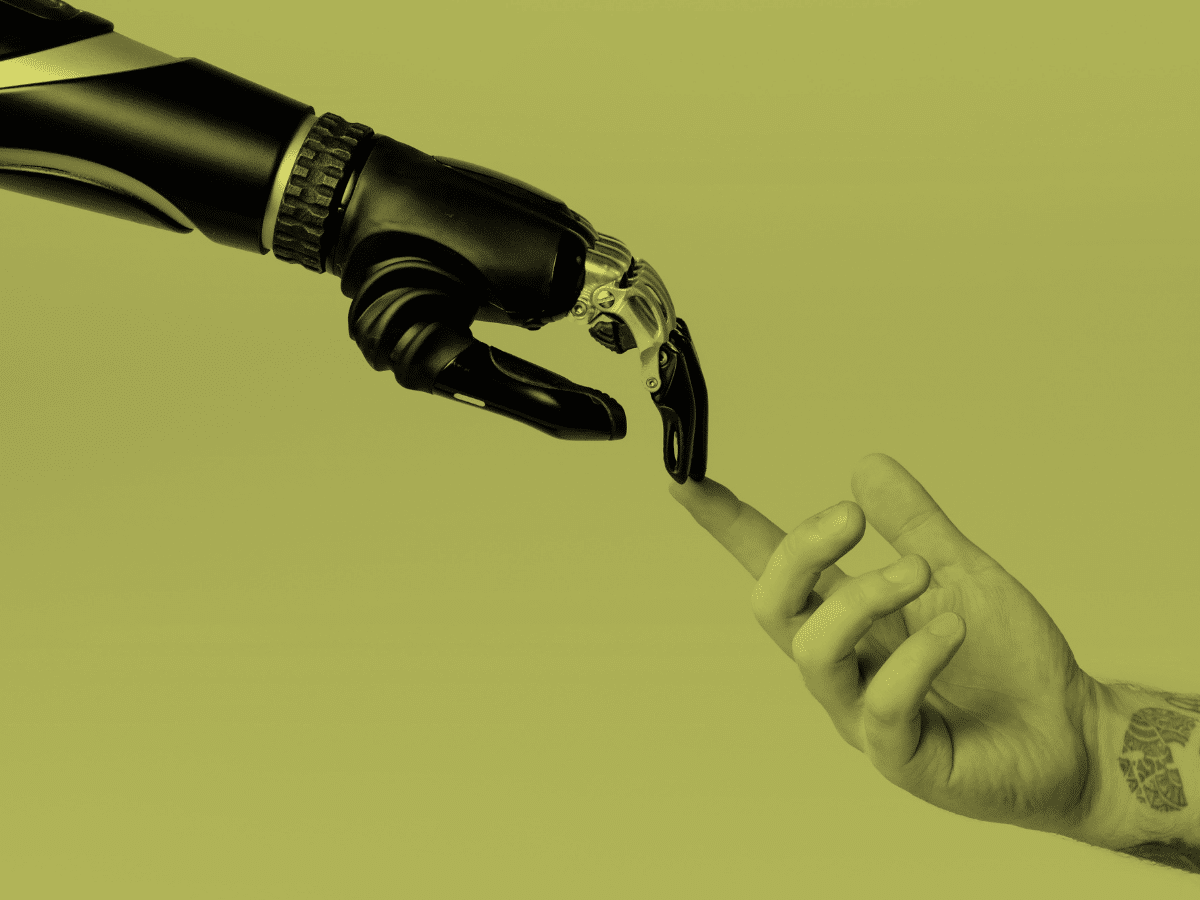 A robotic hand reaches out and touches the finger of a human hand, reminiscent of Michelangelo's "The Creation of Adam." Bathed in a solid yellow background, the human hand displays a visible tattoo on the wrist, encouraging us to disregard the fear-mongering AI industry.