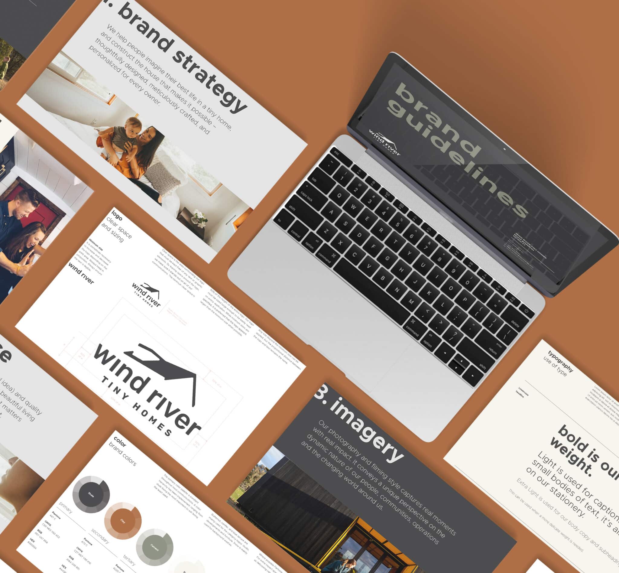 A laptop sits on a brown surface surrounded by various printed brand strategy and guidelines documents. The Big Brand materials include images, graphics, and text about brand strategy, imagery, and brand guidelines for "Wind River Tiny Homes.