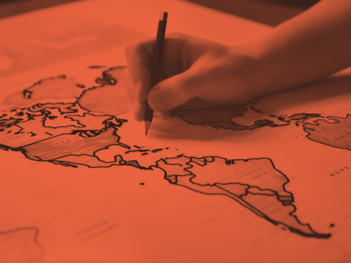 Hand sketching borders on a stylized world map, symbolizing strategic global expansion and cross-border planning.