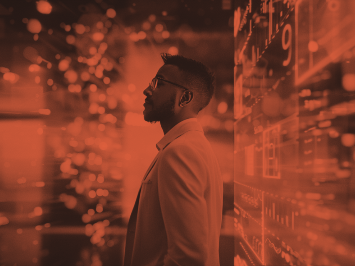 Modern commercial leader standing in front of digital performance dashboards, symbolizing data-driven growth and hybrid leadership.