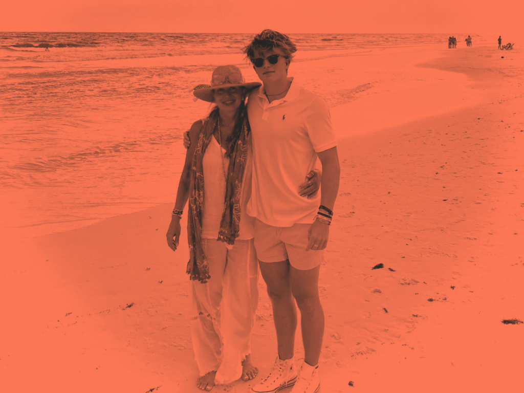 Burnt orange duotone portrait of a smiling woman and young man standing together on a beach, representing personal growth and reflection on a year of fractional work at Chameleon Collective.